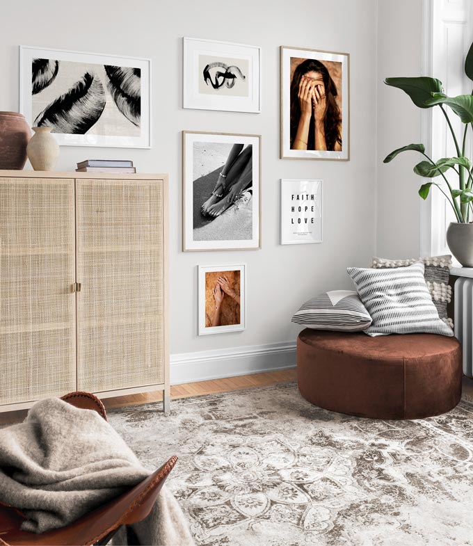 Partial view of living space with a gallery wall that includes a typography print and a stunning cane sideboard that adds depth and texture. Image by Desenio.