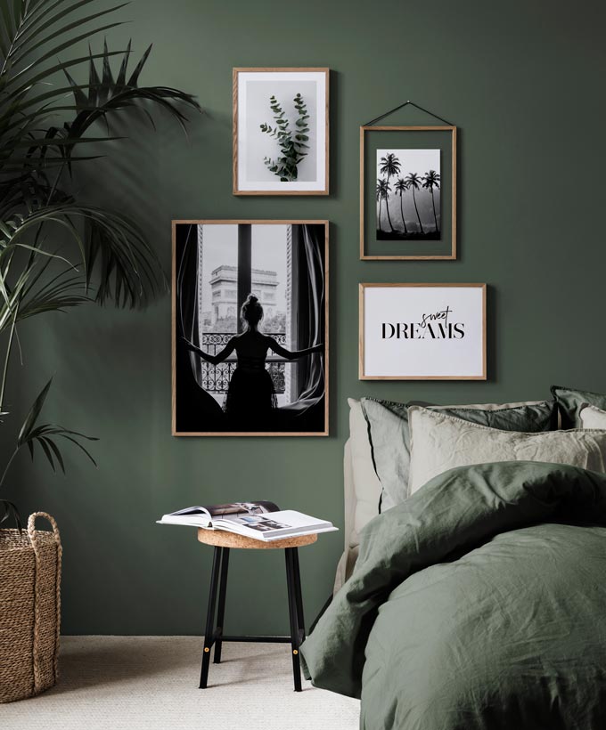 A contemporary green bedroom featuring a black and white gallery wall that includes some typography. Image by Desenio.