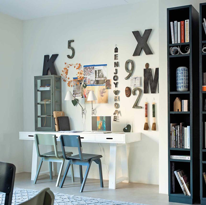 A cool white desk with a wall filled with typography decor to spice it all up. Image by Cuckooland.