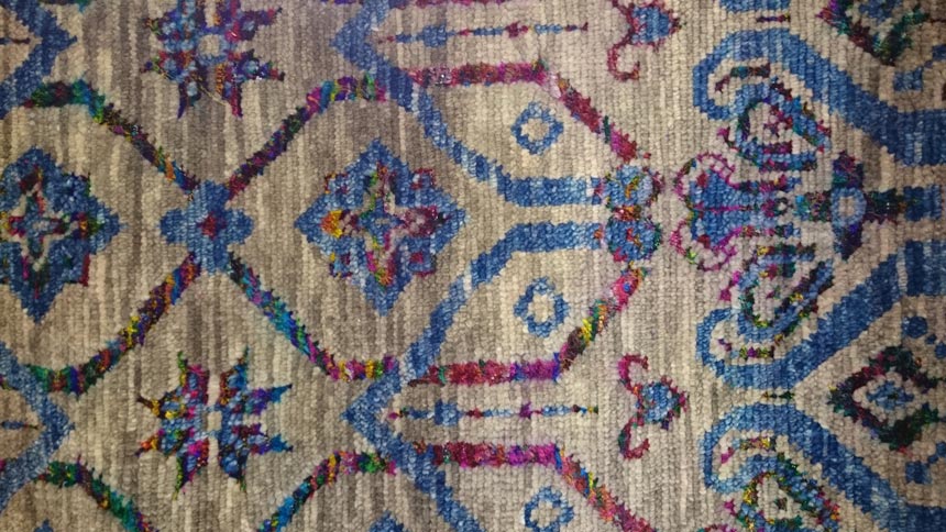 Detail of a pattern of a blue area rug.
