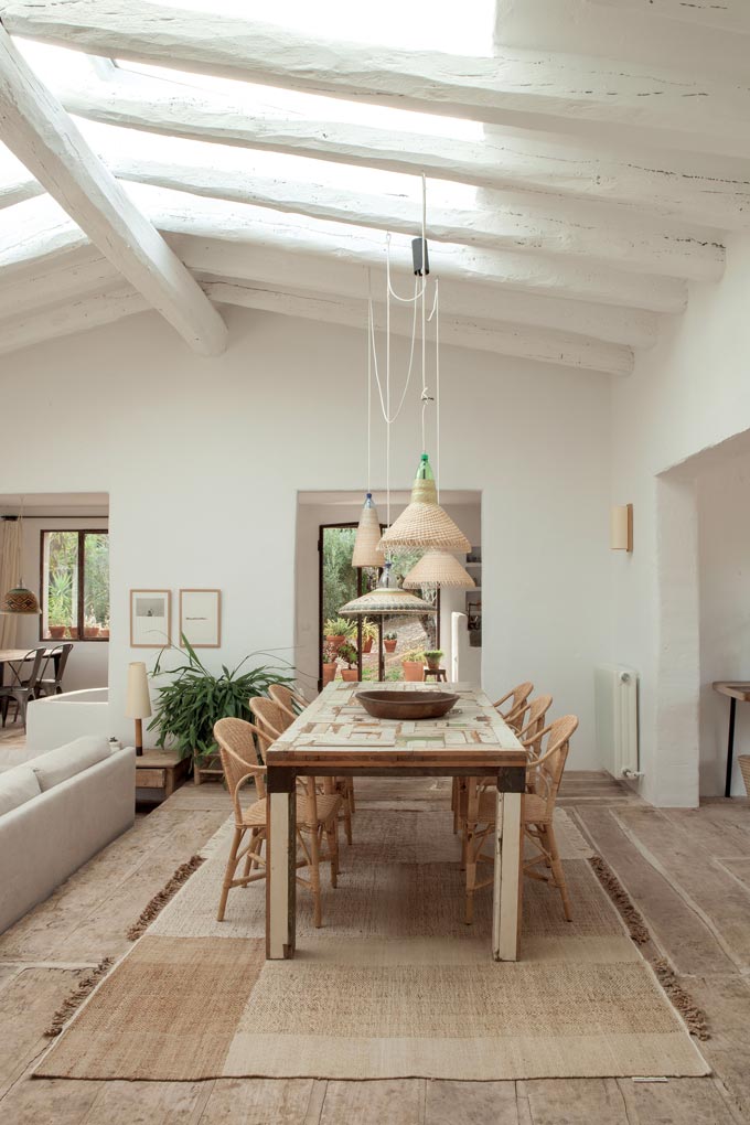 A rustic dining space with a neutral area rug under it that despite its rustic vibe, feels fresh and modern. Image by Nest.co.uk.