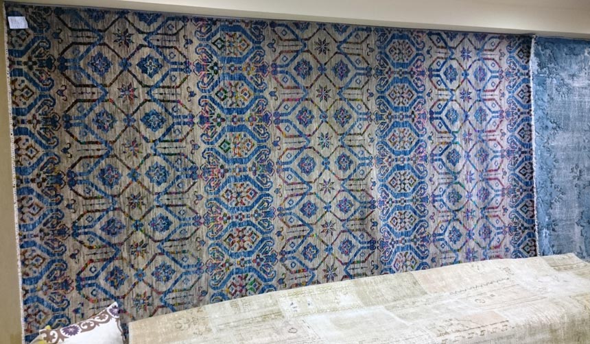 A blue patterned silk area rug on display.