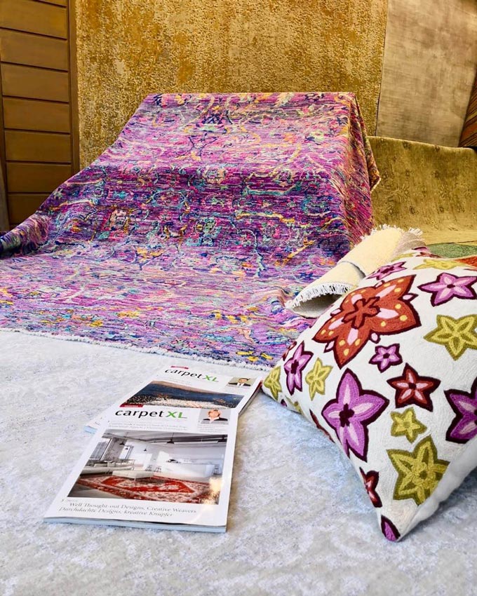 A beautiful pinkish area rug on display in a rug store