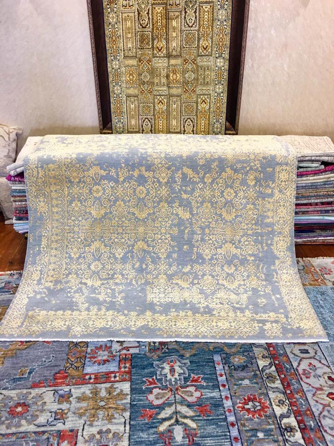 Three different in style area rugs on display in a rug store.