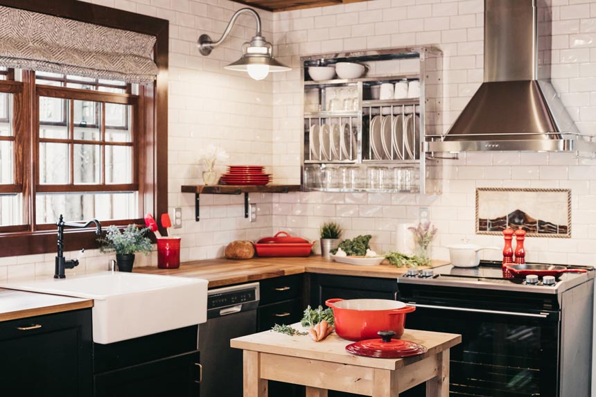 An eclectic style kitchen with black cabinetry, red accents and open shelving.