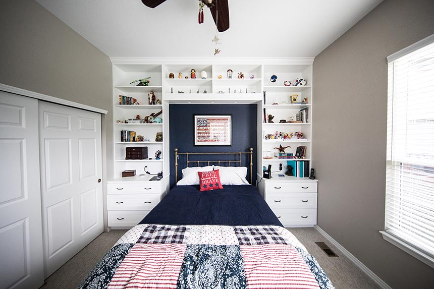 A stylish boy's bedroom with a built bookcase around the bed.