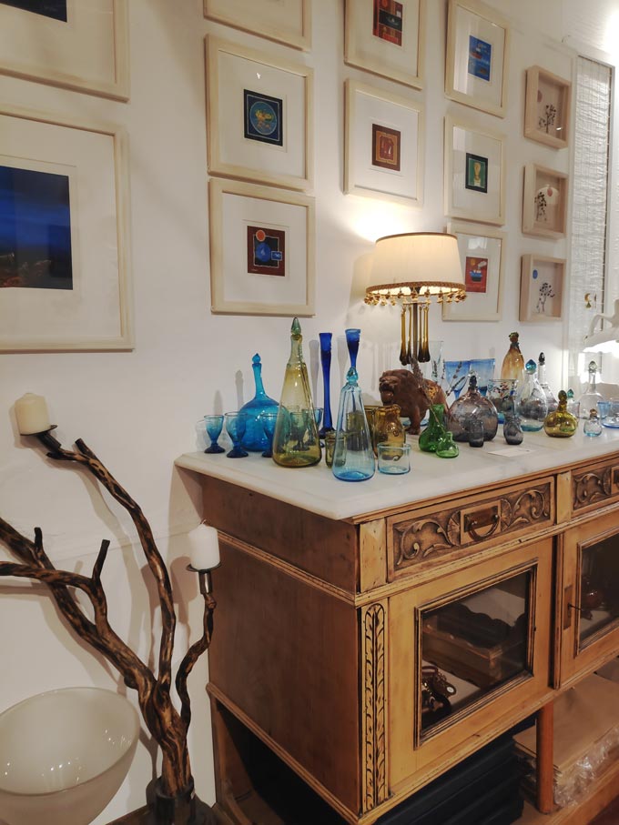 View of an orderly gallery wall with art images over a vintage upcycled credenza. Image by Velvet.