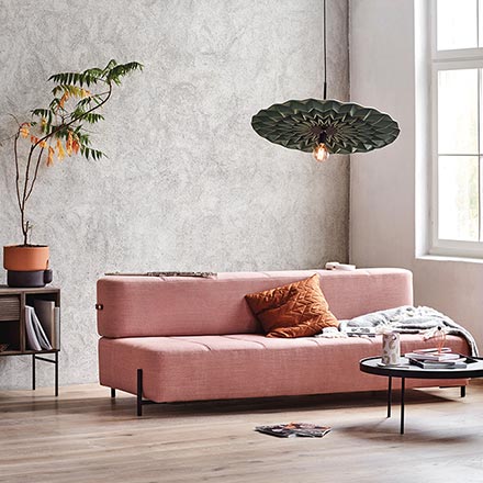 A pink modern sofa bed in a warm minimal setting. Image by Nest.