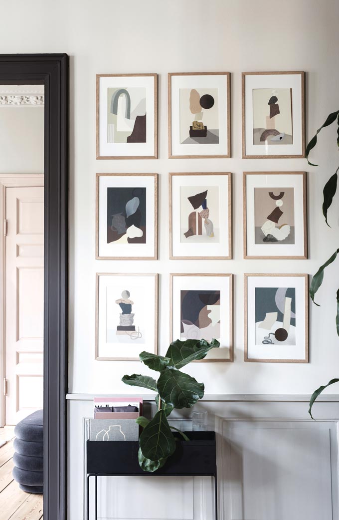 An art gallery wall above a black Ferm Living planter box. Image by Nest.