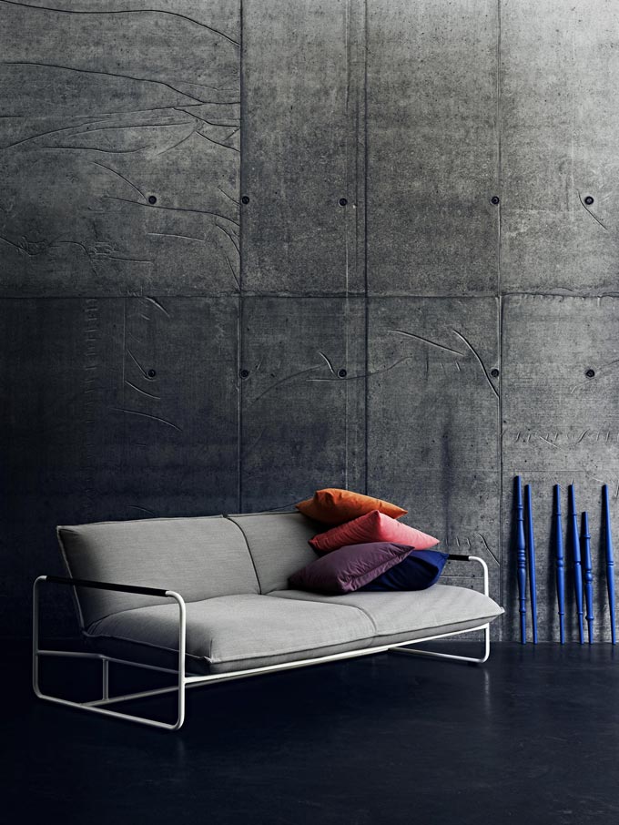 That is an jaw dropping grey sofa bed with a sleek frame to it against a concrete wall. Image by Nest.co.uk.