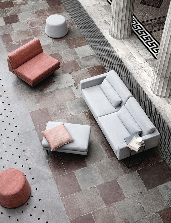 A beautiful minimal light gray sofa and pouf along with an armless chair as seen from above. Image by Nest.co.uk.