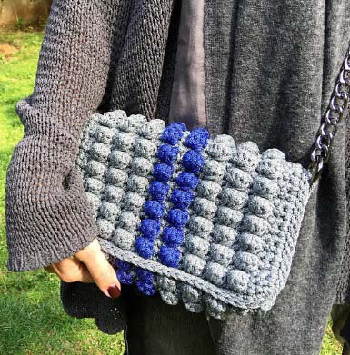 Detail view of a handmade grey crochet bag