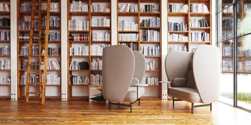 A large home library room with two Fritz Hansen Plenum armchairs that make a huge statement yet provide an incredible sense of discreteness. Image by Nest.