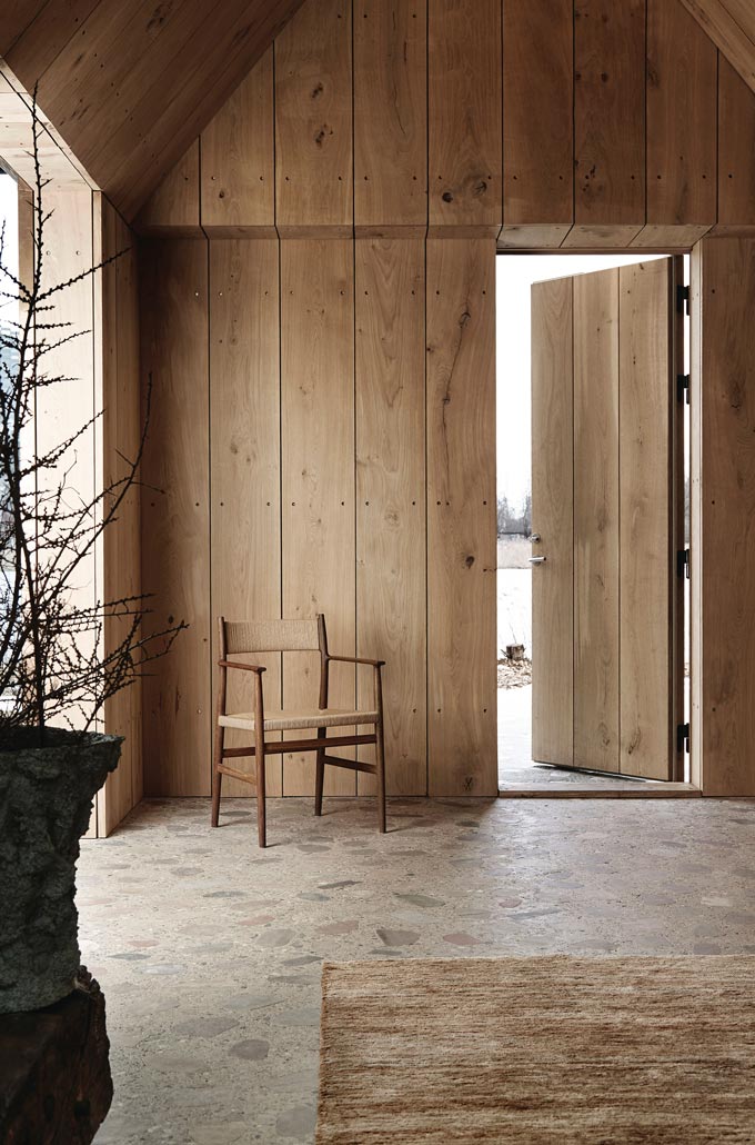 The Brdr. Krüger ARV Dining Chair standing in front of a wooden entrance. The noticeable attribute of this image is the color harmony and that includes the beige like terrazzo flooring. Image by Nest.