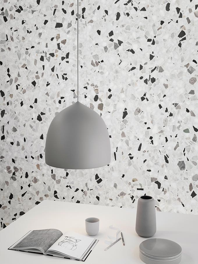 The Lightyears Suspence Pendant Light Designed by GamFratesi, stands out in front of a terrazzo wallpaper treatment.