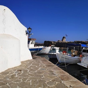 Partial view of the port of Naoussa in Paros with the white chapel on the left. Image by Velvet.