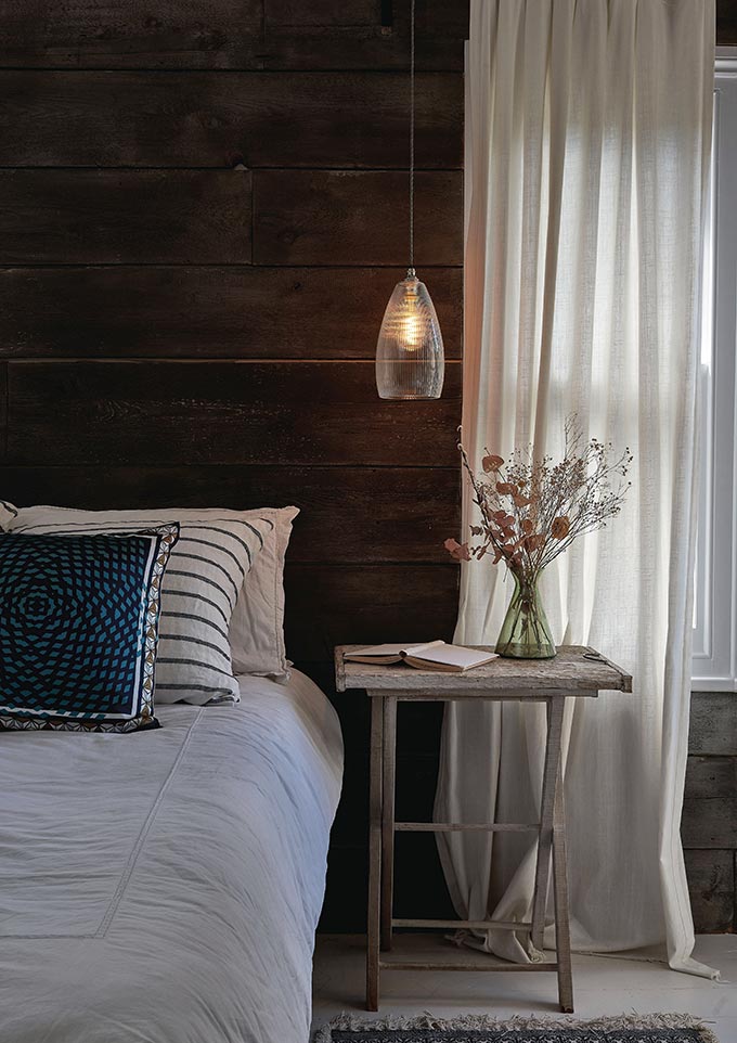Basics lighting design: A bedroom vignette with a tray table to the side of a bed and a glass pendant light over it. Image by Fritz fryer.