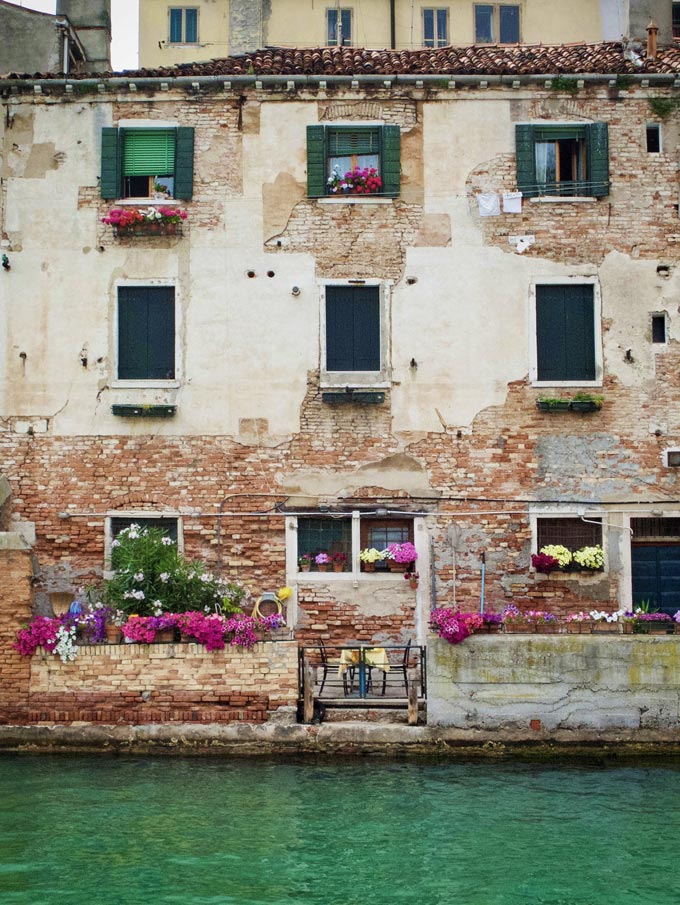 An old building in Venice with green Venetian blinds.