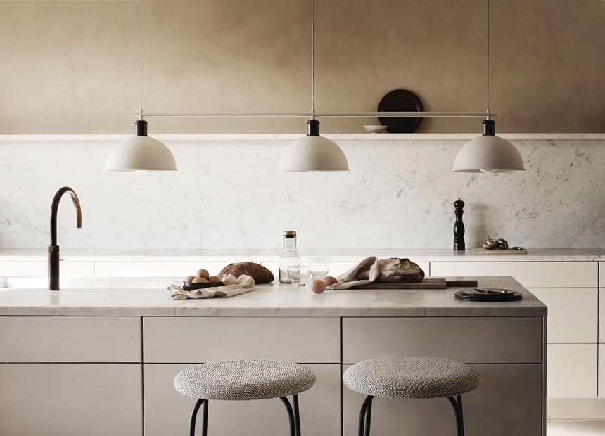 Three pendant lights hanging over a kitchen island. Image by Nest.