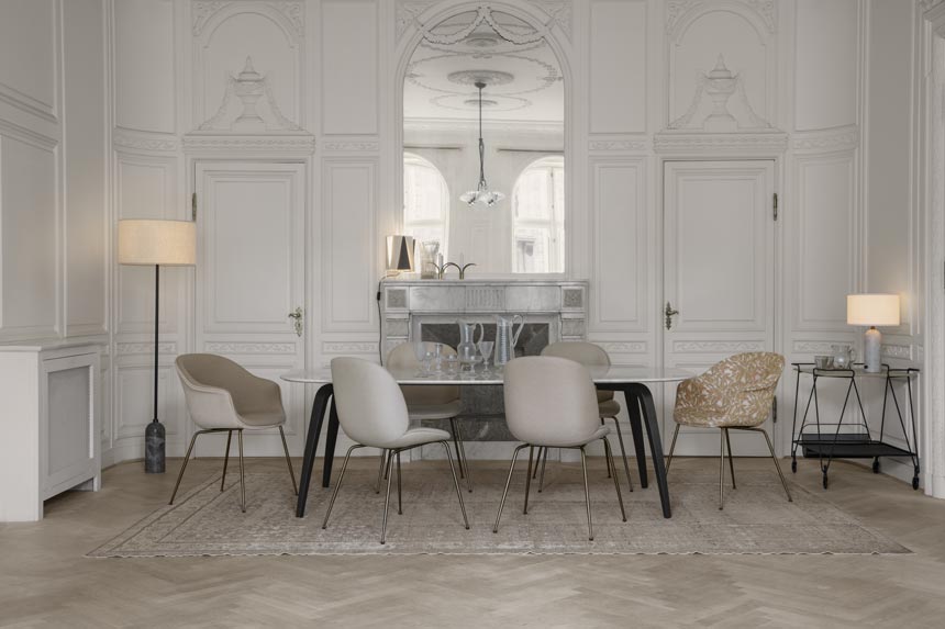 An elegant white interior with an accent high ceiling, a huge mirror in the center over a fireplace and a contemporary minimal dining set. Lighting adds on to its understated glamour. Image by Nest.co.uk.