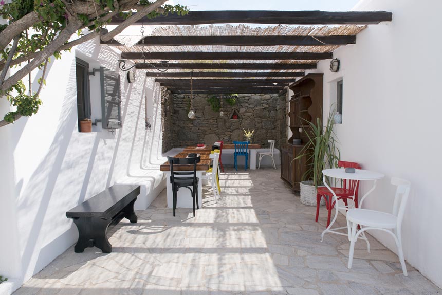 A cycladic minimal outdoor setting for dining under a pergola in a housing complex at Mykonos. Image by Antonis Drakakis.