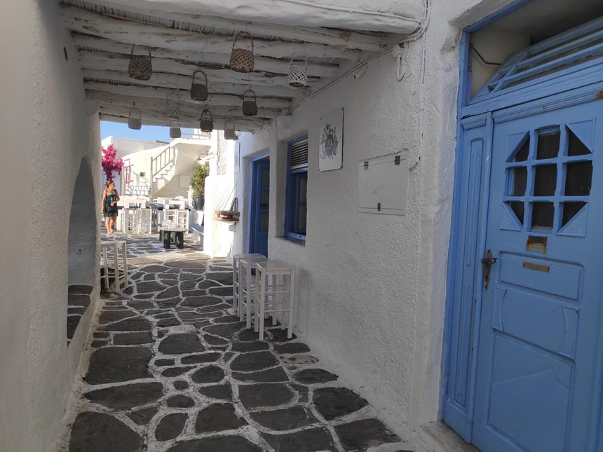 A underpass walkway with paved stone slabs near the scenic port of Naoussa in Paros.