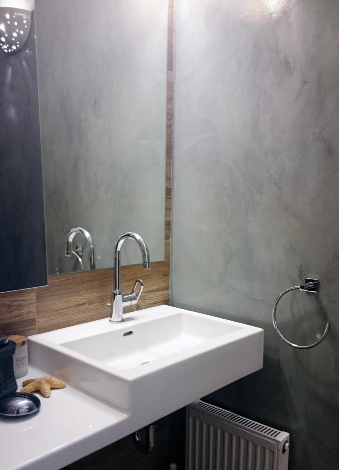 Partial view of my bathroom with its grey microcement wall and my white Laufen washbasin.