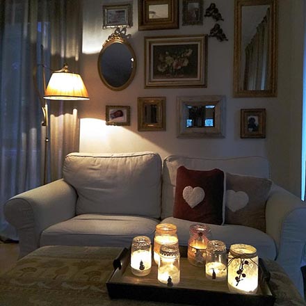 This is one of Elisabeth's vignettes.A cozy vignette with a two seater sofa, a coffee table, a gallery wall as a backdrop and plenty of candles to add that hygge vibe.