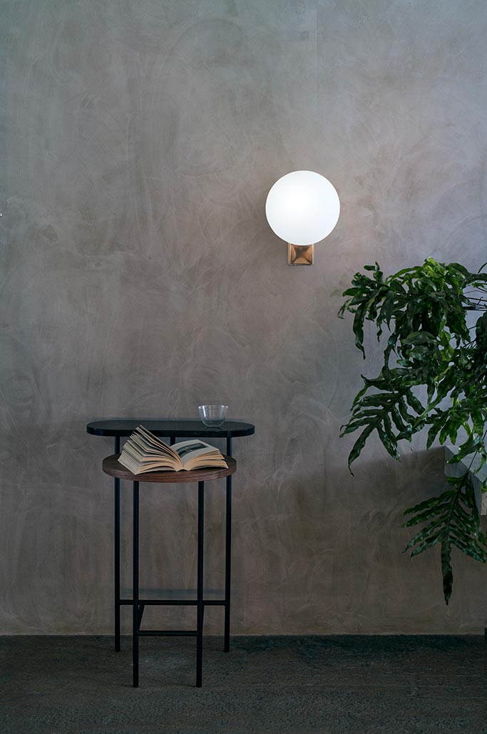 The &Tradition; Journey SHY2 wall light featured on a microcement wall. Image by Nest.co.uk.