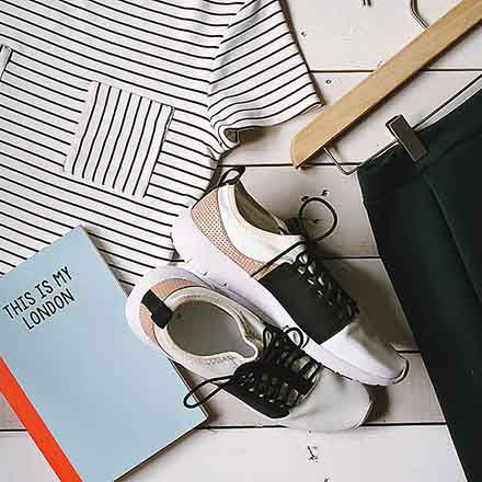 A flatlay of a Breton shirt, a notebook, a pair of shoes and a pair of black pants