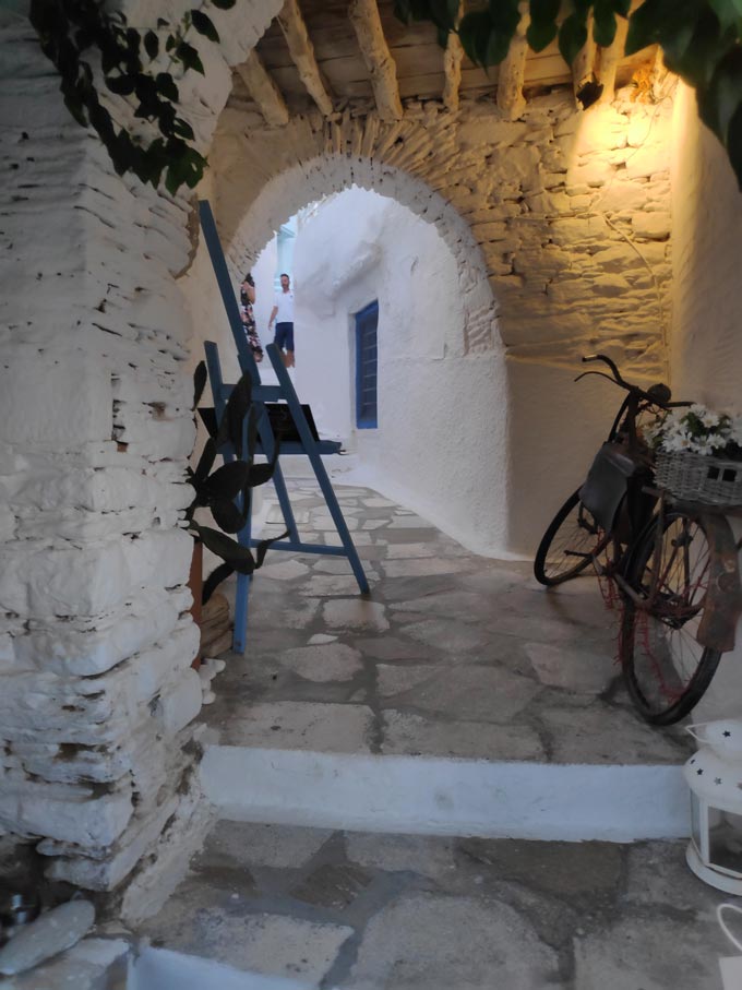 An old bike used as decor under an alley passage in Ano Syros. Image by Velvet.