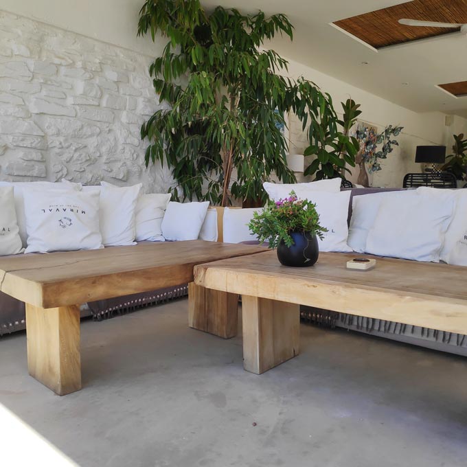 A contemporary rustic living room with white sofas and rustic coffee tables.