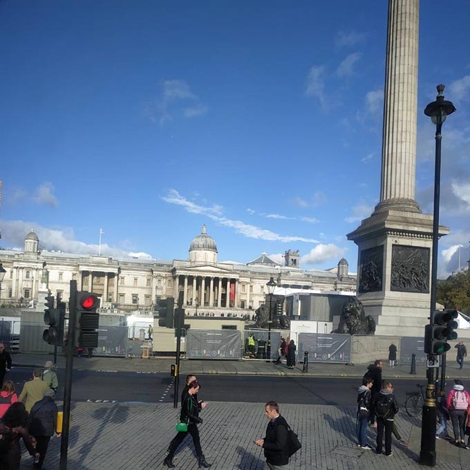 The main exterior facade of the building that hosts the National Gallery in London, with lots of people on the Trafalgar Square