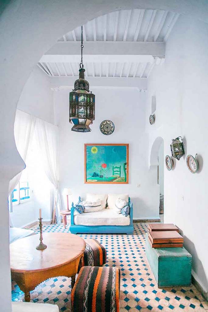 A white Moroccan interior with old pattern pink and green floor tiles