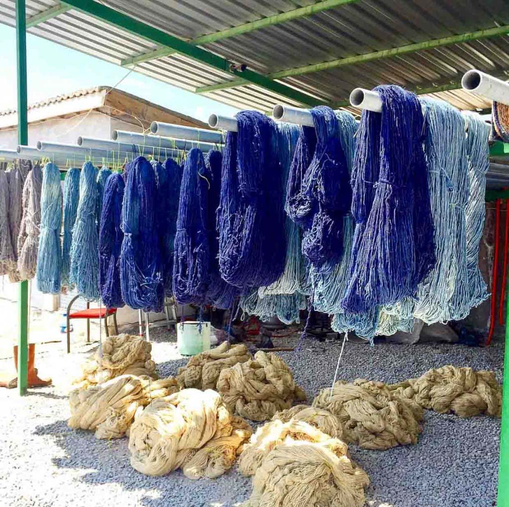 Blue yarns being hung whilst air-drying