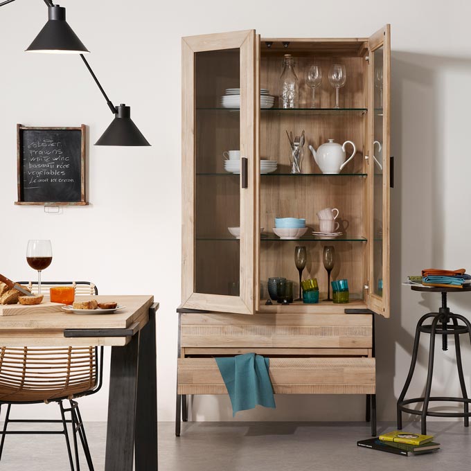 A wooden cabinet with industrial legs filled with decor looks great next to a stool. Image by Cuckooland.