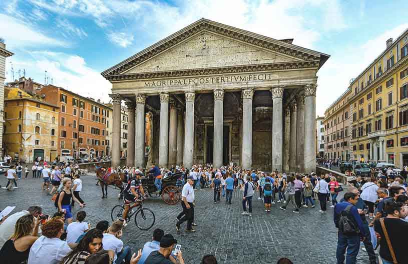 View of the exterior of the Pantheon in Rome with lots of passerbys