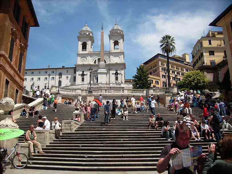 View of the Spanish steps in Rome with the church atop and lots of tourists about