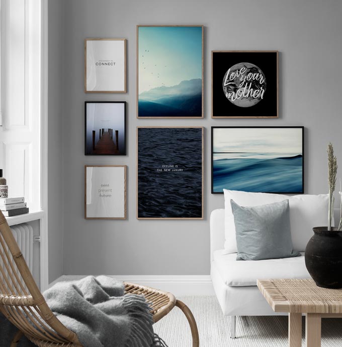 A nature inspired theme gallery wall creates a serene focal point in a bright minimal living room. Image by Desenio.
