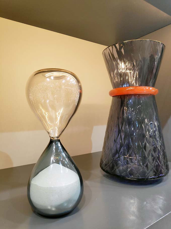 An hourglass and a colored glass Venini vase. Image by Velvet.