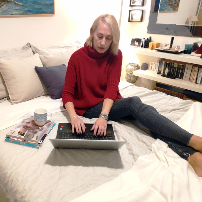 Velvet on a bed working on her laptop.