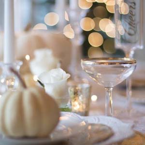 Detail image of a Thanksgiving place setting with a small white pumpkin on a white china plate