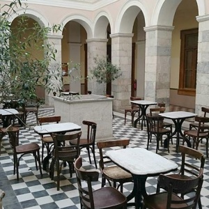 A traditional coffee house setup inside an atrium of Hermoupolis town hall. Image by Velvet.