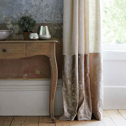 What an awesome detail of a console table by a door window. Both the wall and the curtain are color blocked in muted terracotta shades. Very French. Image by Dunelm.