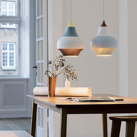 Two beautiful Louis Poulsen pendant lamps over a dining table create a hygge ambiance. Image by Nest.co.uk