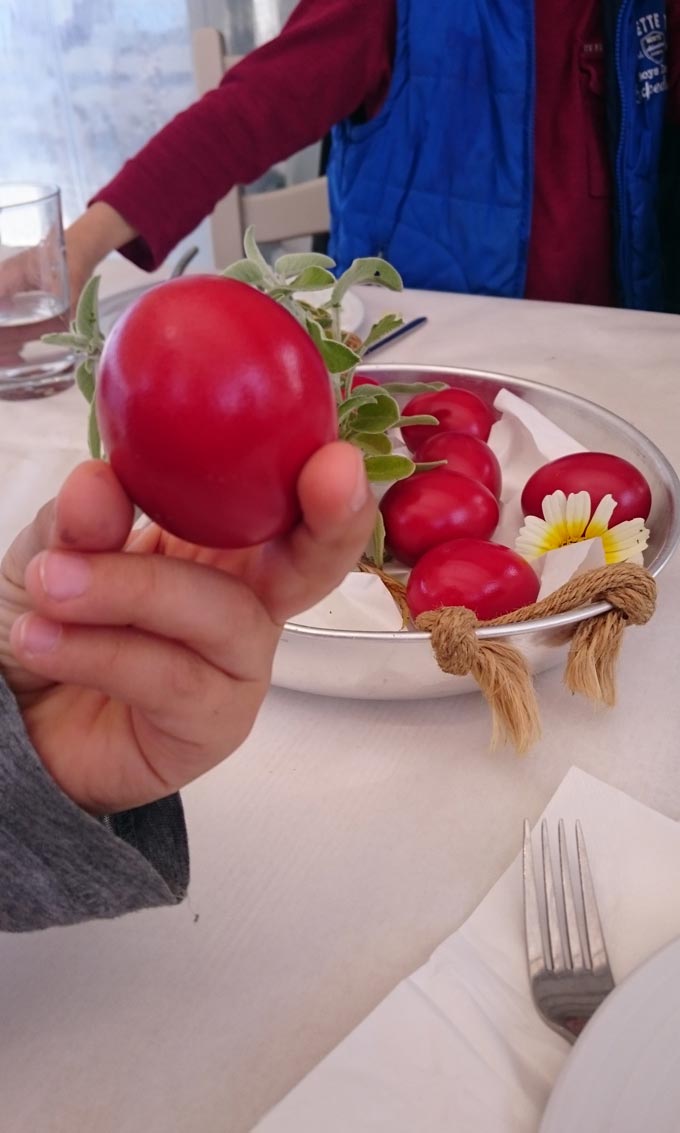 My son holding a red Easter egg just before the custom of cracking them begins.