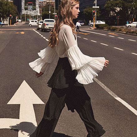 This is one serious style statement white shirt with fluffs on the sleeves. Combined with black wide leg pants that also have fluffs, looking gorgeous. Image by Girls on Film.