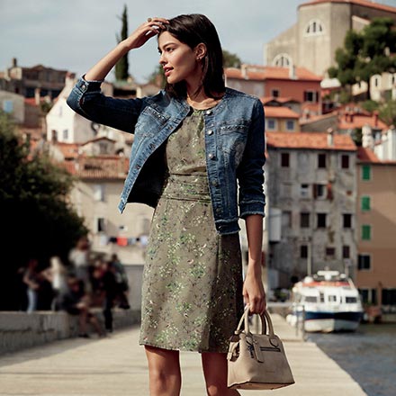 A denim jacket (low key element) paired with a dress and statement shoes in a sage green color (both high key elements). Image by Betty Barclay.