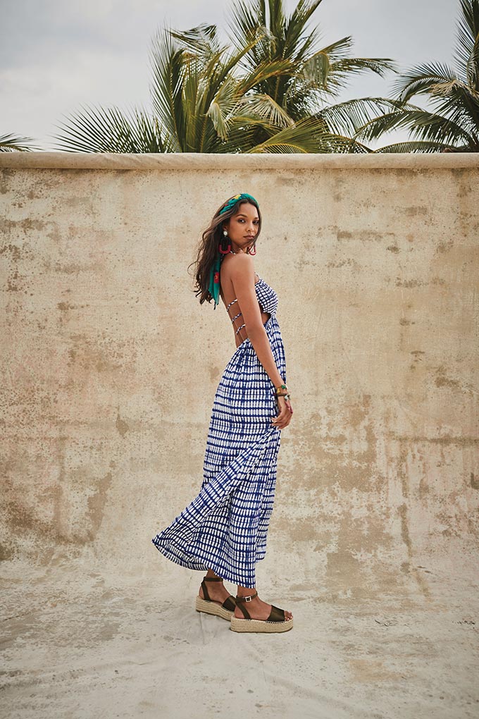 Summer vacation outfit ideas: A beautiful maxi dress with think blue and white stripes looking stunning on a brunette model with long hair styled with a headband. Image by Matalan.
