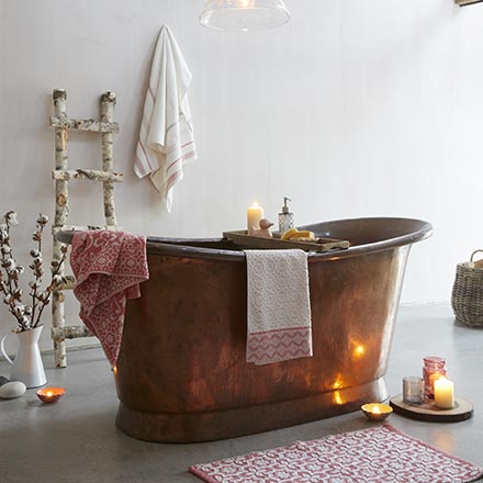 A soothing ambiance in a bathroom like this is dreamy. A copper free standing tub, soft towels and lit candles - is all you need. Image by Dunelm.